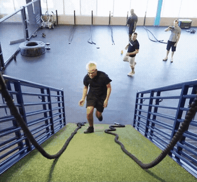 A Man Runs Up A Set Of Stairs With Ropes GIF