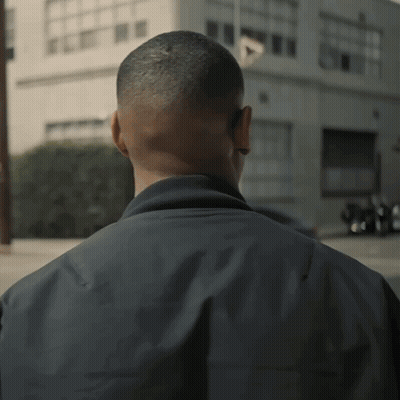 A Man 'S Back Is Shown In A Blurry Photo With A Building In The Background GIF