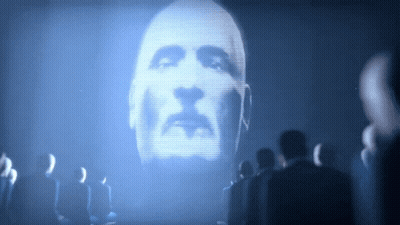 A Man 'S Face Is Projected On A Large Screen GIF