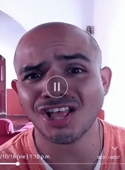 A Man 'S Face Is Shown In A Video With A Pause Button In The Corner GIF