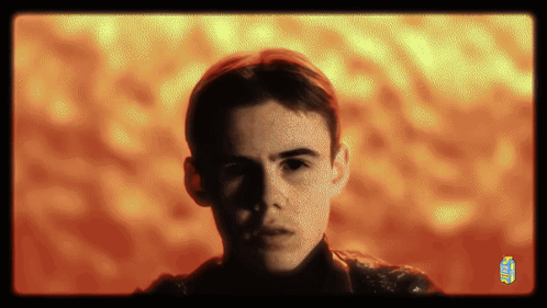 A Man 'S Face Is Shown In Front Of A Yellow And Orange Background With A Juice Box In The Corner GIF
