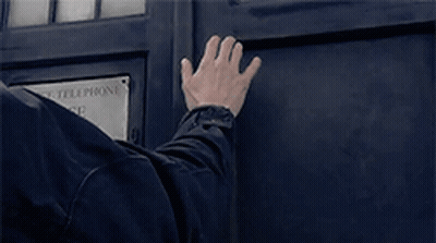 A Man 'S Hand Is Reaching Out To A Police Telephone Box GIF