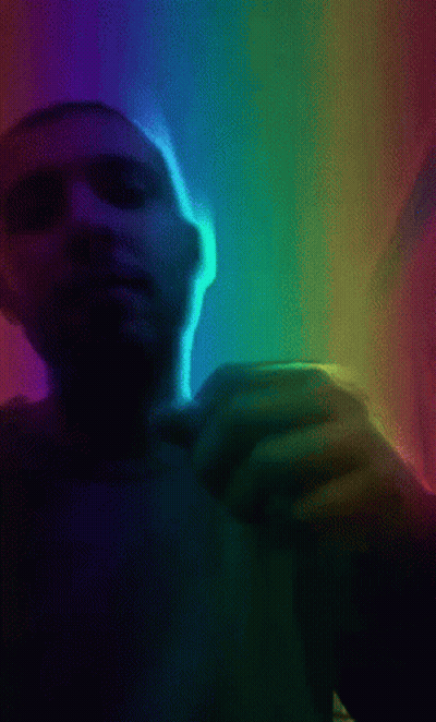 A Man 'S Hand Is Reaching Out Towards A Rainbow Light GIF
