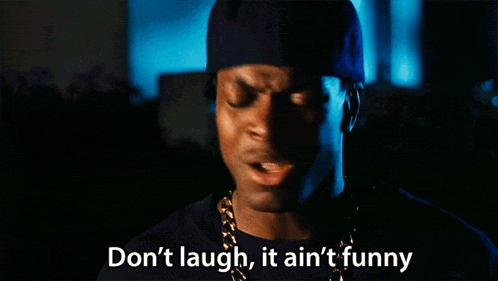 A Man Says " Don 'T Laugh It Ain 'T Funny " In Front Of A Dark Background GIF