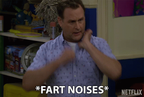 A Man Says " Fart Noises " In Front Of A Shelf Of Toys GIF
