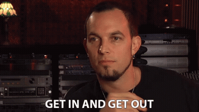 A Man Says Get In And Get Out In Front Of A Stack Of Electronics GIF