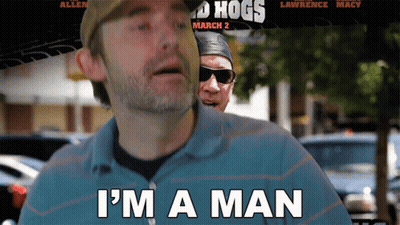 A Man Says I 'M A Man In Front Of A Movie Poster For Hogs March 2 GIF