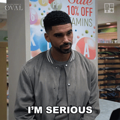 A Man Says I 'M Serious In Front Of A 10 % Off Vitamins Sign GIF