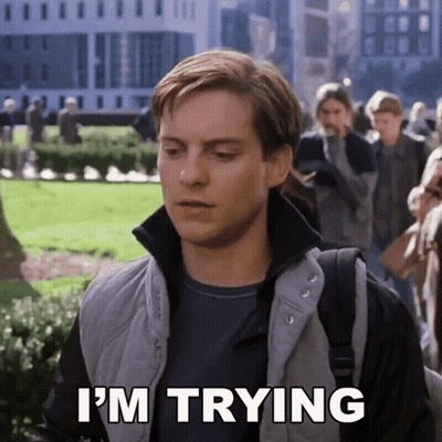 A Man Says I 'M Trying While Walking In A Park GIF