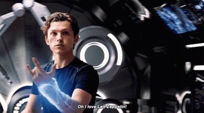 A Man Says " Oh I Love Led Zeppelin " In Front Of A Large Screen GIF