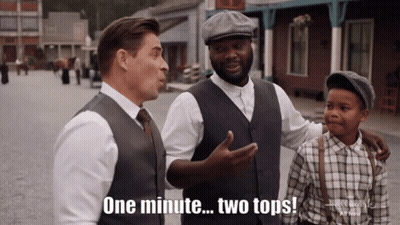 A Man Says One Minute Two Tops In Front Of Two Other Men GIF
