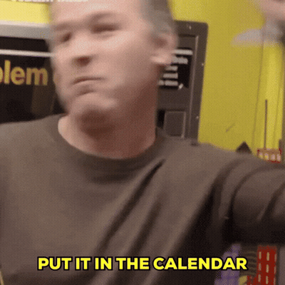 A Man Says Put It In The Calendar In Front Of A Yellow Wall GIF