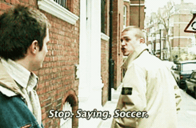 A Man Says Stop Saying Soccer In Front Of A Brick Building GIF