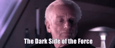 A Man Says The Dark Side Of The Force In A Dark Room GIF