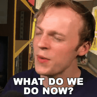 A Man Says What Do We Do Now In Front Of A Shelf GIF