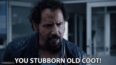 A Man Says You Stubborn Old Coot In Front Of A Door GIF