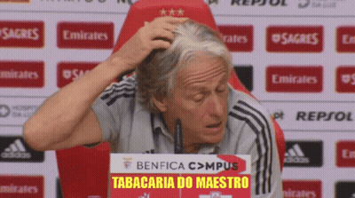 A Man Scratches His Head In Front Of A Sign That Says Benfica Campus Tabacaria Do Maestro GIF