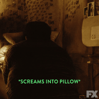 A Man Screams Into A Pillow In A Dark Room GIF