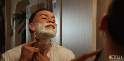 A Man Shaving In Front Of A Mirror With A Netflix Logo GIF