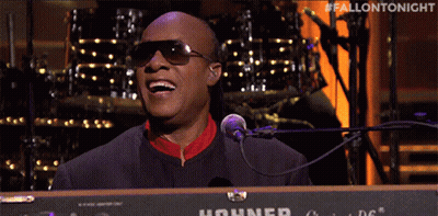A Man Singing Into A Hohner Keyboard With The Hashtag #Fallontonight GIF