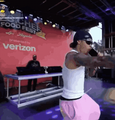 A Man Singing Into A Microphone At A Food Fest GIF