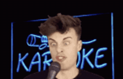 A Man Singing Into A Microphone In Front Of A Neon Sign That Says Karaoke . GIF