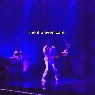 A Man Singing Into A Microphone On A Stage With The Words Me If U Even Care On The Bottom GIF