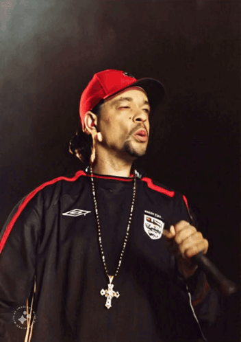 A Man Singing Into A Microphone Wearing A Jersey That Says England On It GIF