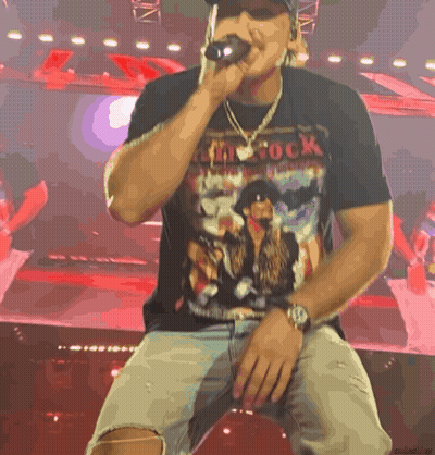 A Man Singing Into A Microphone Wearing A Shirt That Says ' My Rock ' GIF