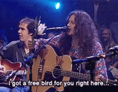 A Man Singing Into A Microphone While Another Man Plays A Guitar GIF
