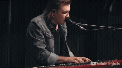 A Man Singing Into A Microphone While Playing A Keyboard With Youtube Originals On The Bottom GIF