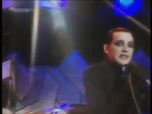 A Man Singing Into A Microphone With A Bbc Four Logo In The Corner . GIF
