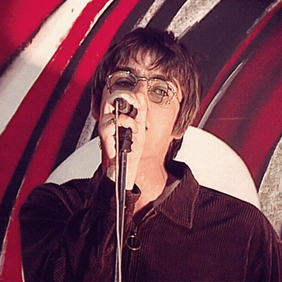 A Man Singing Into A Microphone With A Red White And Black Background GIF