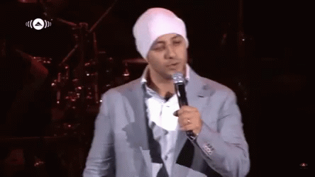 A Man Singing Into A Microphone With An Arrow Pointing To The Left GIF