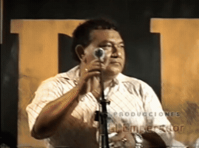 A Man Singing Into A Microphone With The Word Producciones On The Bottom Right GIF