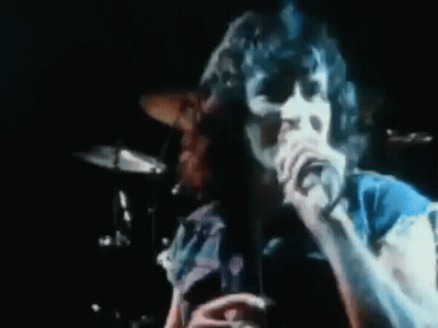 A Man Singing Into A Microphone With The Word Seems In Red GIF