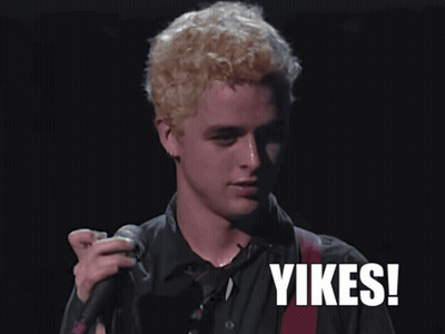 A Man Singing Into A Microphone With The Word Yikes On The Bottom Right GIF