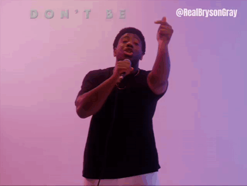 A Man Singing Into A Microphone With The Words " Do N't Be Spoiled " Above Him GIF
