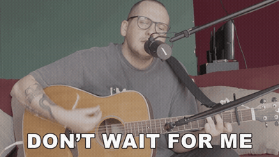 A Man Singing Into A Microphone With The Words " Don T Wait For Me " Above Him GIF