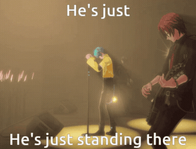 A Man Singing Into A Microphone With The Words He 'S Just He 'S Just Standing There On The Bottom GIF