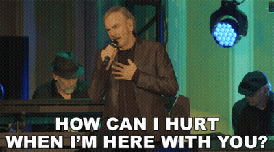 A Man Singing Into A Microphone With The Words " How Can I Hurt When I 'M Here With You " GIF