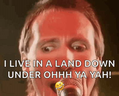 A Man Singing Into A Microphone With The Words " I Live In A Land Down Under Ohh Ya Yah " GIF