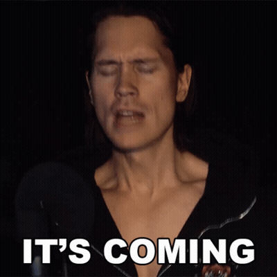 A Man Singing Into A Microphone With The Words It 'S Coming Above Him GIF