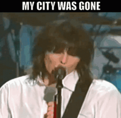 A Man Singing Into A Microphone With The Words " My City Was Gone " Above Him GIF