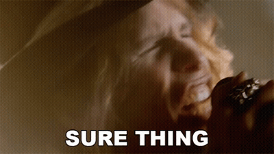 A Man Singing Into A Microphone With The Words " Sure Thing " Behind Him GIF
