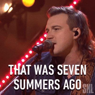 A Man Singing Into A Microphone With The Words That Was Seven Summers Ago Below Him GIF