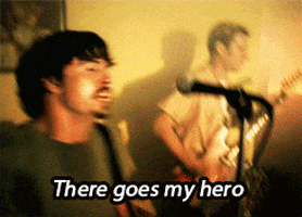 A Man Singing Into A Microphone With The Words " There Goes My Hero " GIF