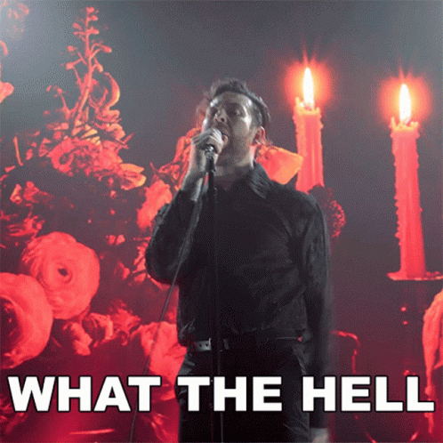 A Man Singing Into A Microphone With The Words " What The Hell " Behind Him GIF