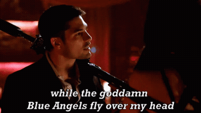 A Man Singing Into A Microphone With The Words While The Goddamn Blue Angels Fly Over My Head GIF