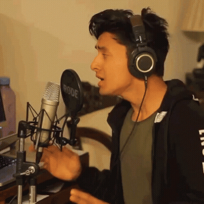 A Man Singing Into A Rode Microphone With Headphones On GIF